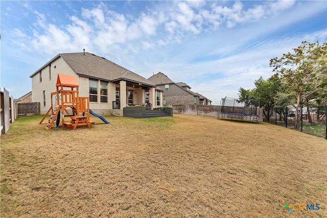 1620 Craftsman, New Braunfels, TX 78132 - rear view of house with a trampoline, a playground, brick siding, and a fenced backyard