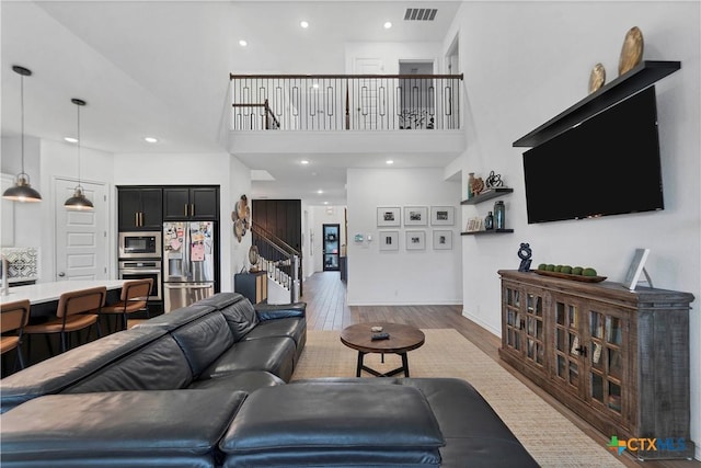 1620 Craftsman, New Braunfels, TX 78132 - living area featuring stairs, wood finished floors, a towering ceiling, and recessed lighting