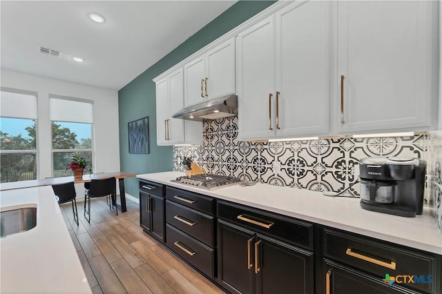 1620 Craftsman, New Braunfels, TX 78132 - kitchen featuring white cabinetry, dark cabinetry, under cabinet range hood, light countertops, and stainless steel gas cooktop