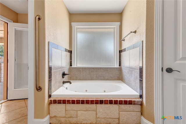 bathroom with tiled bath and tile patterned floors