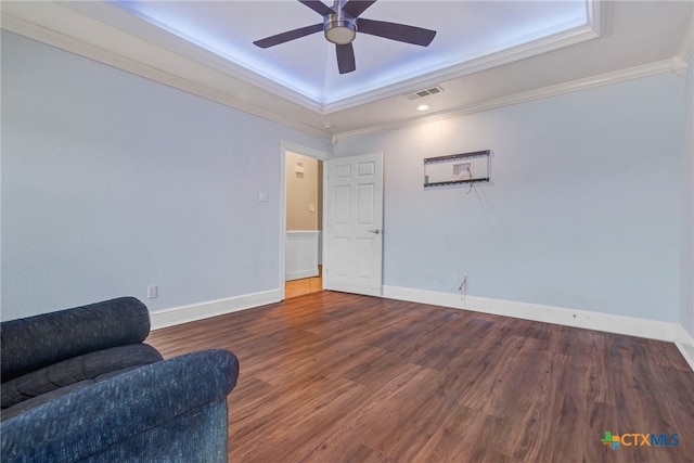 sitting room with a raised ceiling, crown molding, ceiling fan, and wood-type flooring