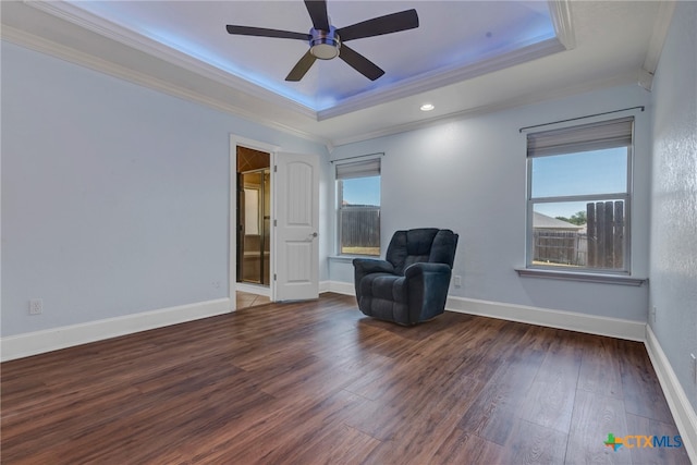 unfurnished room featuring dark hardwood / wood-style floors, ceiling fan, a raised ceiling, and ornamental molding