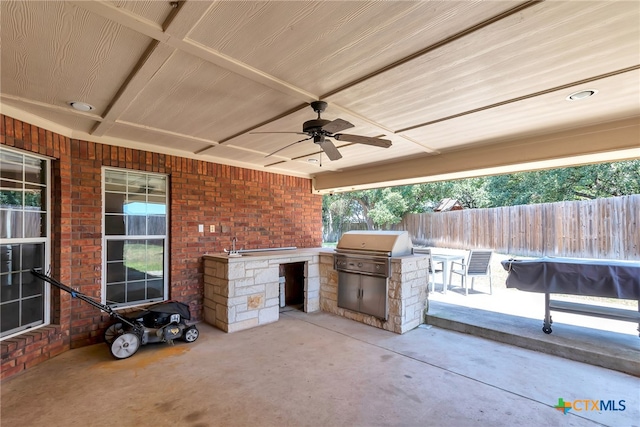 view of patio featuring area for grilling, ceiling fan, and exterior kitchen