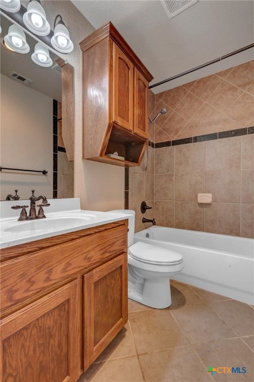 full bathroom with tile patterned floors, toilet, vanity, and tiled shower / bath