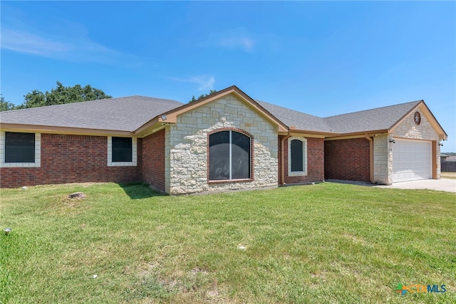 ranch-style house featuring a garage and a front lawn