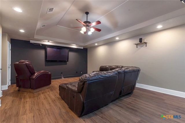 cinema with a raised ceiling, ceiling fan, and hardwood / wood-style floors