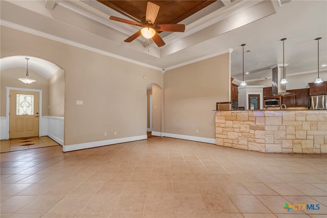 unfurnished living room with light tile patterned floors, a raised ceiling, ceiling fan, and crown molding