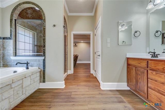 bathroom with vanity, wood-type flooring, shower with separate bathtub, and ornamental molding