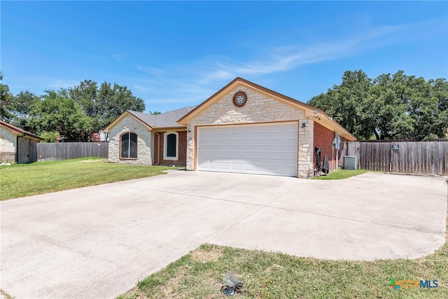 ranch-style home featuring a front yard, a garage, and central air condition unit