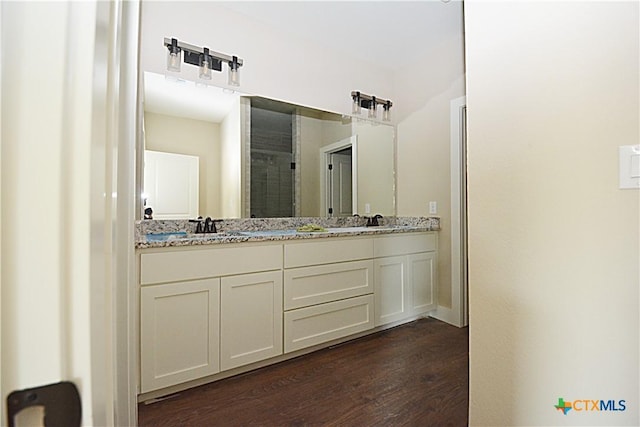1560 Yaupon Dr, Fischer, TX 78623 - full bathroom featuring a shower stall, wood finished floors, double vanity, and a sink
