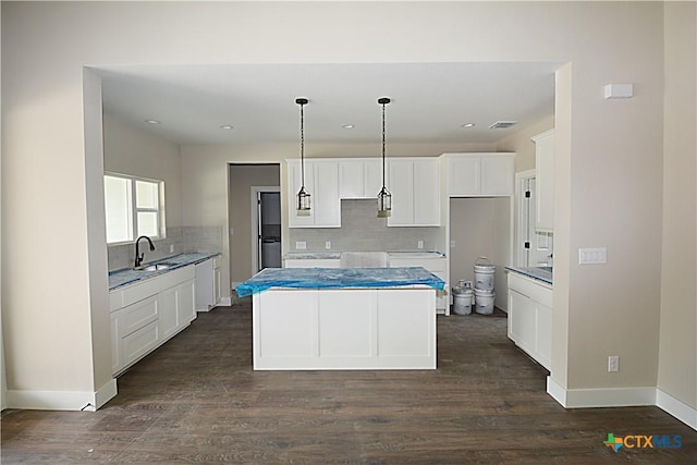 1560 Yaupon Dr, Fischer, TX 78623 - kitchen with a center island, tasteful backsplash, a sink, dark wood-style flooring, and visible vents