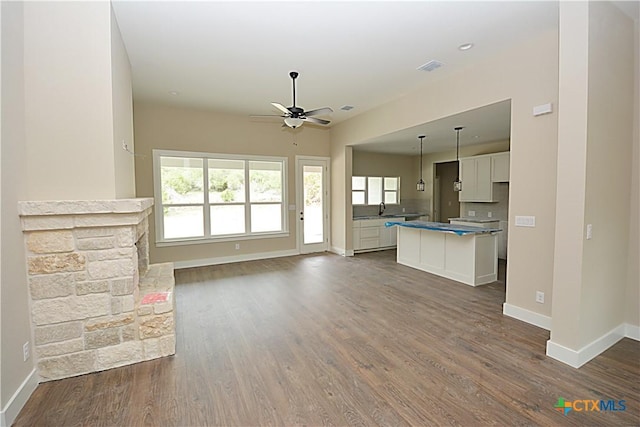 1560 Yaupon Dr, Fischer, TX 78623 - unfurnished living room featuring a ceiling fan, baseboards, and dark wood-style floors