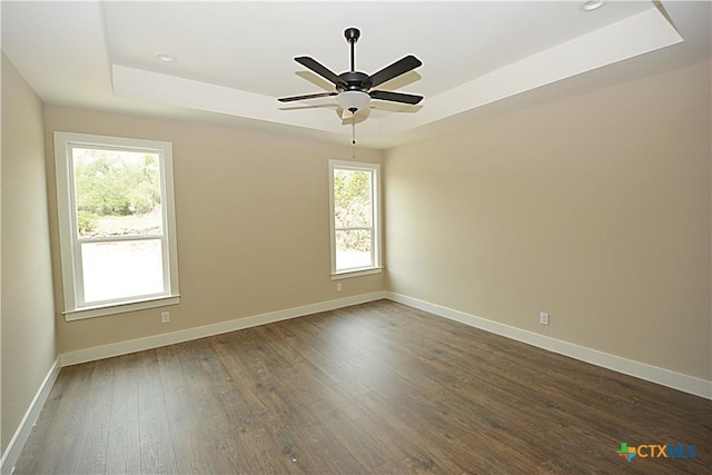 1560 Yaupon Dr, Fischer, TX 78623 - empty room with baseboards, a ceiling fan, a tray ceiling, and dark wood-style flooring
