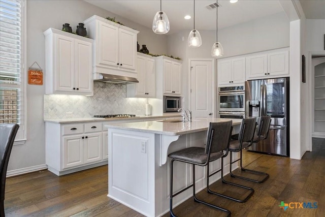 kitchen featuring visible vents, white cabinetry, under cabinet range hood, tasteful backsplash, and appliances with stainless steel finishes