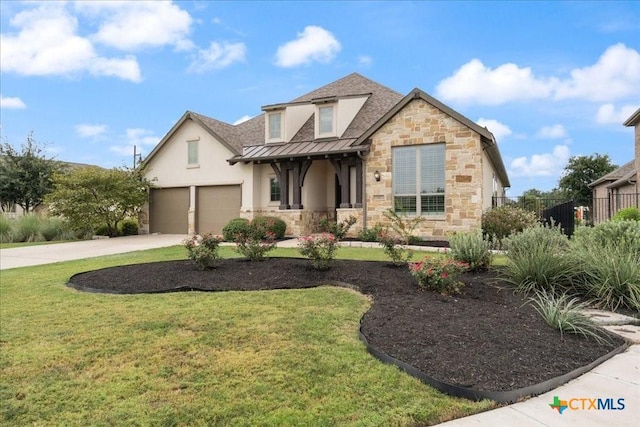 view of front facade with a standing seam roof, a front yard, concrete driveway, stone siding, and stucco siding
