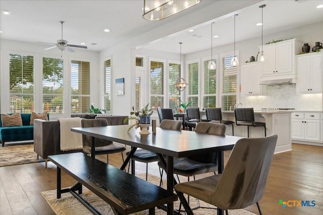 dining room featuring plenty of natural light, recessed lighting, ceiling fan with notable chandelier, and hardwood / wood-style floors