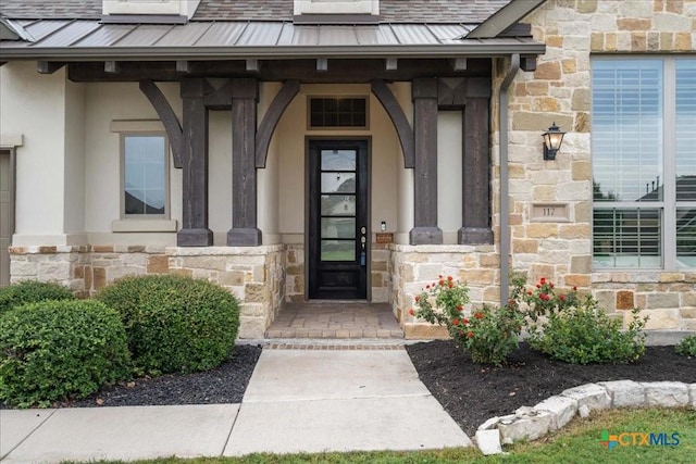 view of exterior entry featuring a standing seam roof, metal roof, and stone siding