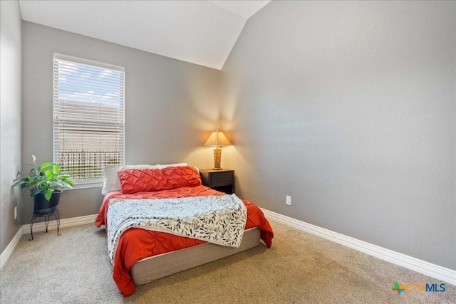carpeted bedroom featuring baseboards, lofted ceiling, and multiple windows
