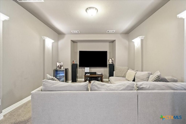 carpeted living area with visible vents, baseboards, and ornate columns