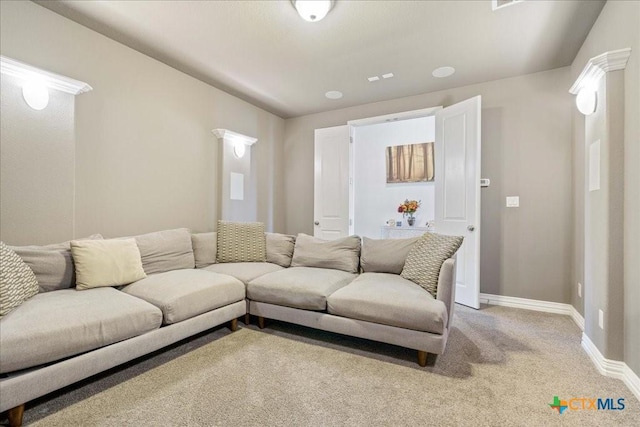 living area featuring baseboards and light colored carpet