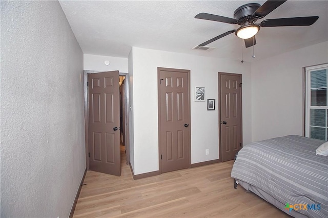 1317 N 10th St, Temple, TX 76501 - bedroom featuring light wood-style floors, baseboards, a textured wall, and ceiling fan