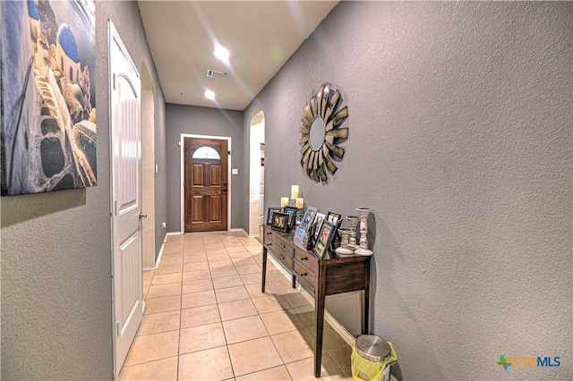 9006 Single Bend Trl, Temple, TX 76502 - doorway with arched walkways, a textured wall, and light tile patterned floors