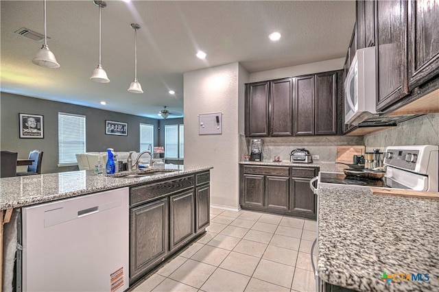 9006 Single Bend Trl, Temple, TX 76502 - kitchen with dishwashing machine, dark brown cabinets, light tile patterned flooring, white microwave, and decorative backsplash