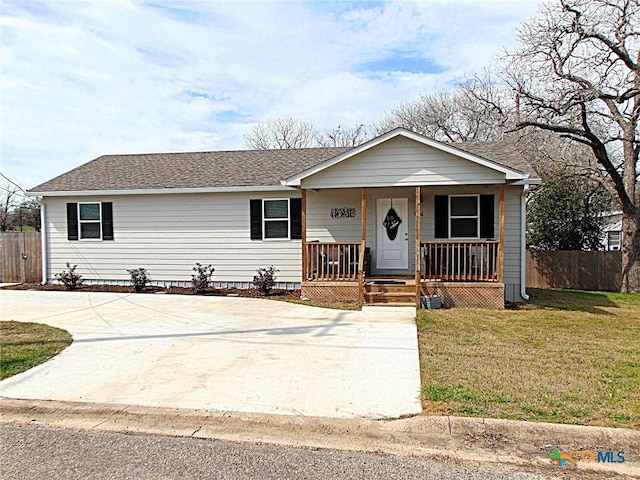 single story home with a porch, a shingled roof, concrete driveway, a front yard, and fence