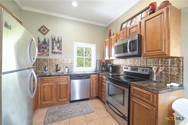 kitchen featuring light tile patterned floors, sink, appliances with stainless steel finishes, and ornamental molding