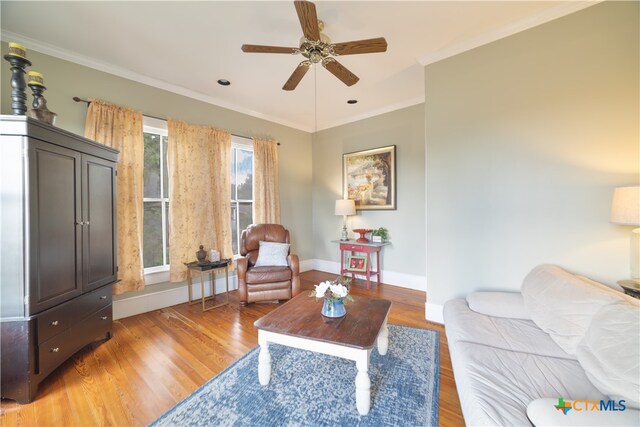 living area featuring light hardwood / wood-style floors, ceiling fan, and crown molding