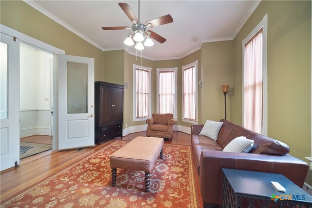 living room featuring ornamental molding, hardwood / wood-style flooring, and ceiling fan