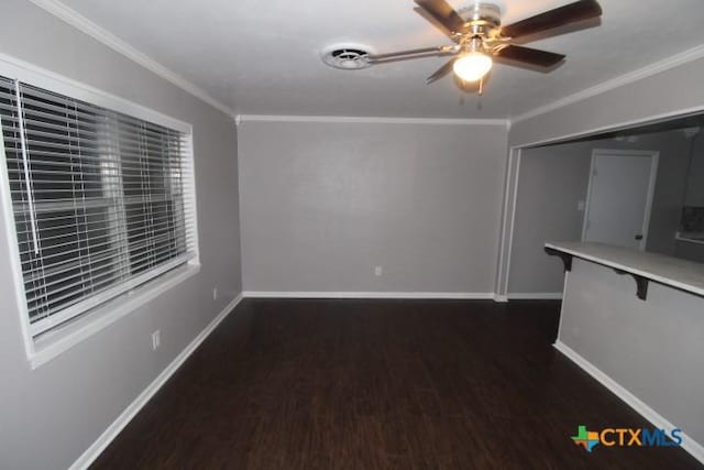 unfurnished room featuring crown molding, ceiling fan, and dark wood-type flooring