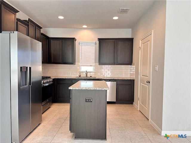 137 Rustic Glen Dr, San Marcos, TX 78666 - kitchen with stainless steel appliances, a sink, tasteful backsplash, light tile patterned flooring, and light stone countertops
