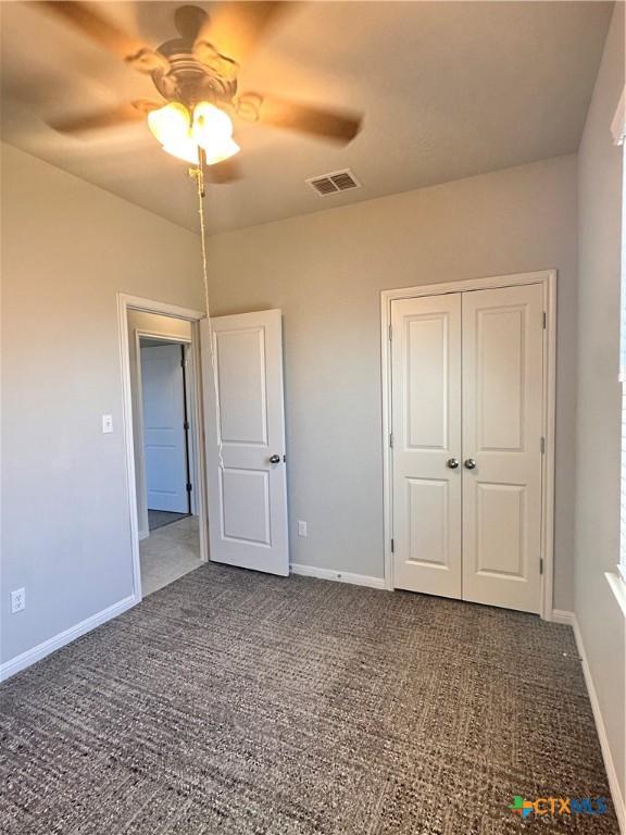137 Rustic Glen Dr, San Marcos, TX 78666 - unfurnished bedroom with carpet flooring, baseboards, a closet, and a ceiling fan