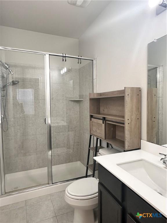 137 Rustic Glen Dr, San Marcos, TX 78666 - full bathroom featuring tile patterned floors, a stall shower, toilet, and vanity