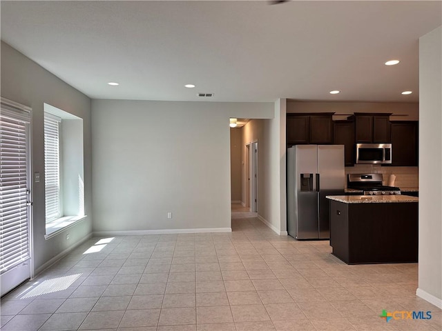 137 Rustic Glen Dr, San Marcos, TX 78666 - kitchen with stainless steel appliances, dark brown cabinetry, light stone countertops, tasteful backsplash, and recessed lighting