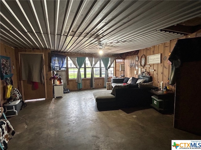 interior space with concrete flooring and wooden walls