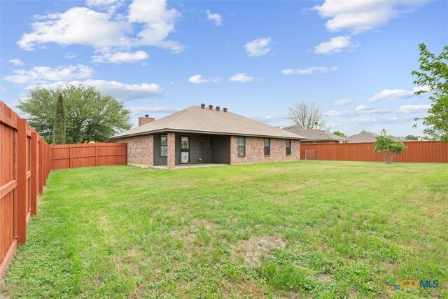 4402 Frontier Trl, Killeen, TX 76542 - rear view of property with a yard, a chimney, and a fenced backyard