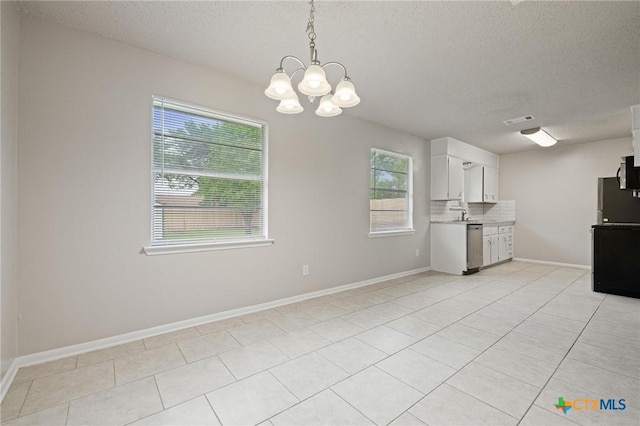 1008 Ronstan Dr, Killeen, TX 76542 - kitchen featuring healthy amount of natural light, a textured ceiling, light countertops, a chandelier, and white cabinetry