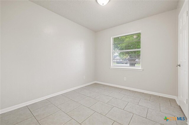1008 Ronstan Dr, Killeen, TX 76542 - empty room featuring a textured ceiling, light tile patterned flooring, and baseboards