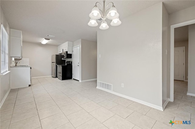 1008 Ronstan Dr, Killeen, TX 76542 - kitchen featuring stainless steel appliances, light tile patterned flooring, a chandelier, and white cabinets