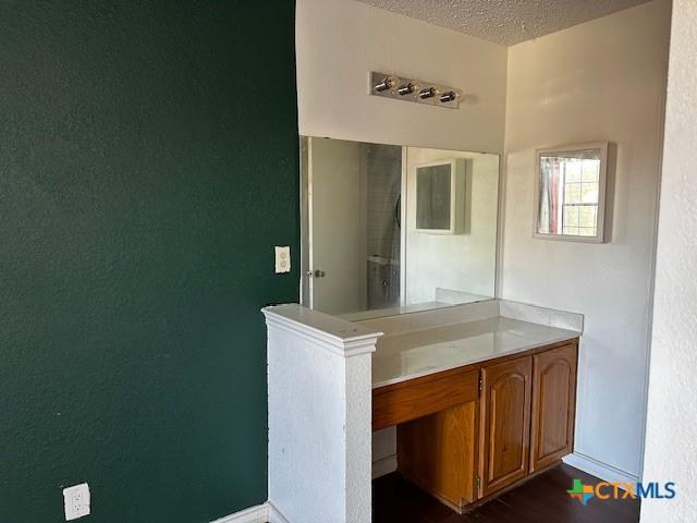 bathroom featuring vanity, wood-type flooring, and a textured ceiling