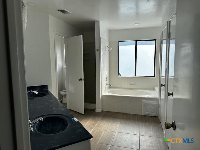 full bathroom with tile patterned flooring, vanity, toilet, and plus walk in shower