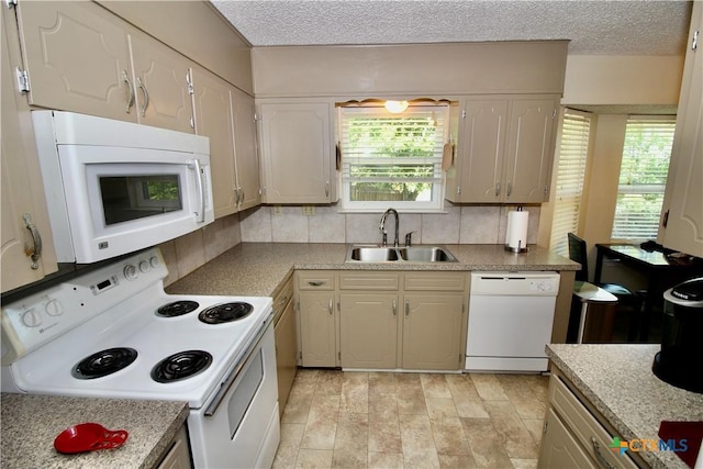 kitchen featuring white appliances, a textured ceiling, decorative backsplash, and a sink