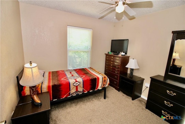 bedroom with carpet floors, a ceiling fan, and a textured ceiling