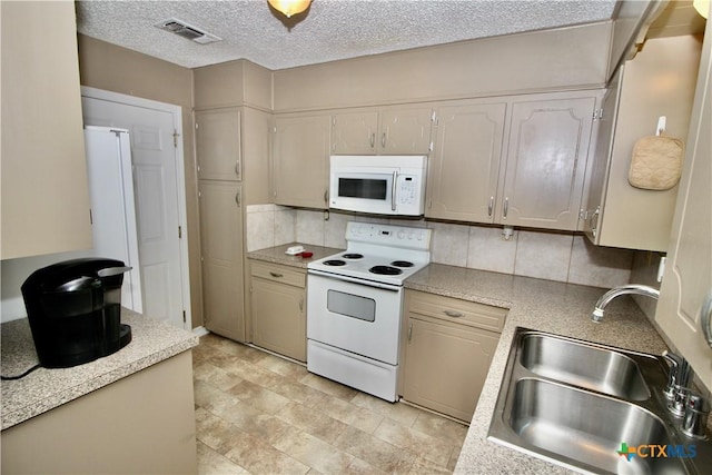 kitchen featuring visible vents, decorative backsplash, white appliances, light countertops, and a sink