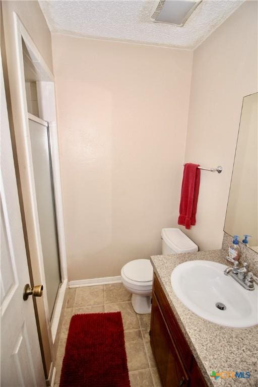 bathroom featuring vanity, toilet, tile patterned floors, a textured ceiling, and a shower stall