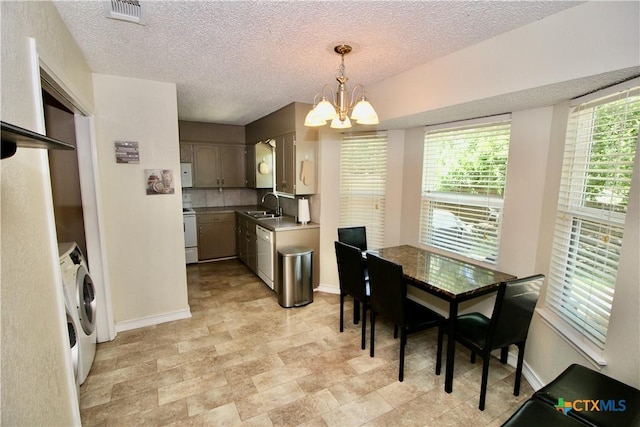 kitchen with a sink, white appliances, a chandelier, washer / clothes dryer, and visible vents