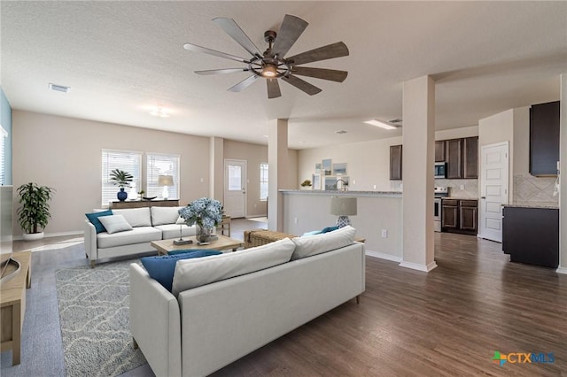 living room featuring ceiling fan and dark hardwood / wood-style floors