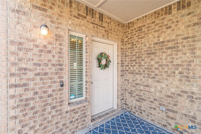 entrance to property featuring brick siding